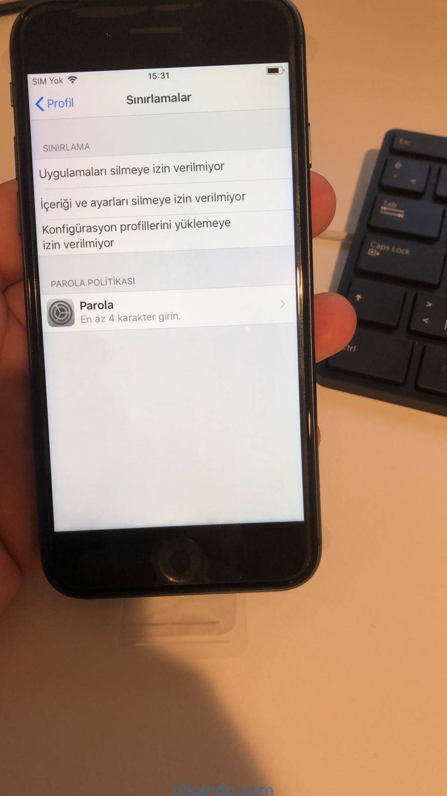 iPhone'da profil sınırlamaları ekranı. Uygulamaları silmeye, içeriği ve ayarları silmeye, konfigürasyon profili yüklemeye izin verilmediği listeleniyor; altta en az dört karakterlik parola politikası var.